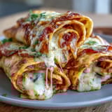 Golden Tortilla Pizza Rolls sliced to show a cheesy, saucy pepperoni center, served warm on a rustic board.