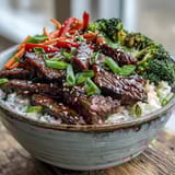 A savory Teriyaki Beef Bowl garnished with fresh green onions and sesame seeds, ready for a quick weeknight dinner.