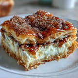 Golden baked sopapilla cheesecake bars layered with rich cream cheese and buttery cinnamon topping, ideal for festive gatherings.