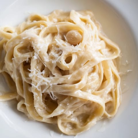 Freshly roasted garlic cloves are mashed into a creamy sauce coating al dente fettuccine pasta, topped with grated Parmesan and parsley.  