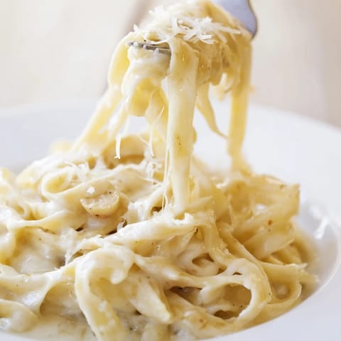 Golden roasted garlic bulbs are squeezed for a luscious cream sauce tossed with fettuccine and finished with freshly grated Parmesan cheese.  