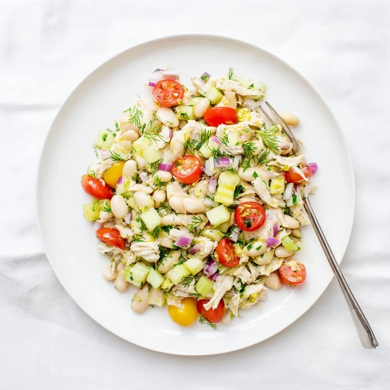 Vibrant Lemony White Bean Chicken Salad featuring crisp celery, red onion, and cherry tomatoes, perfect for a Mediterranean-inspired main dish or picnic side.