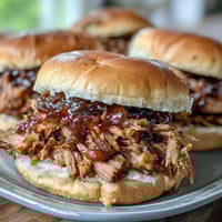 Savory Applesauce Pulled Pork Sandwiches piled high on a soft bun, topped with creamy coleslaw for the ultimate sweet and savory bite.