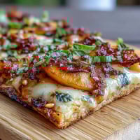 Grilled flatbread with juicy peaches, melted Brie, and smoky BBQ sauce—summer appetizer perfection.  